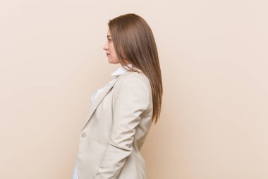 Genç iş kadını sola bakıyor, yana doğru poz veriyor.