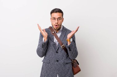 Beyaz bir duvara karşı genç iş filipinli adam şaşırttı ve şok.