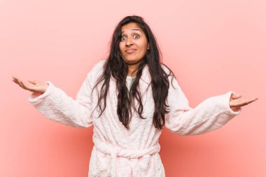 Genç hintli kadın pijama giyen şüphe ve sorgulama jest onu omuzsilke.