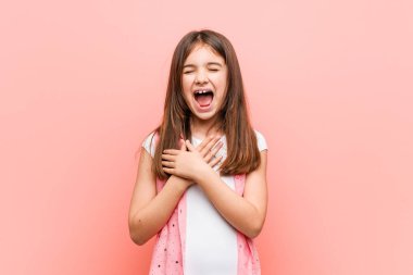 Sevimli küçük kız kalp, mutluluk kavramı ellerini tutarak gülüyor.