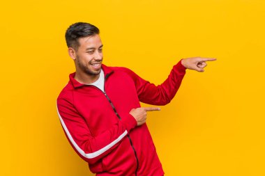 Genç filipinli fitness adam uzakta forefingers ile işaret heyecanlı.