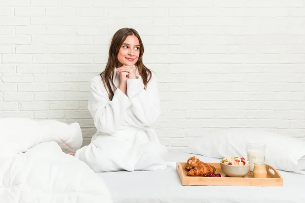 Jonge Blanke Vrouw Het Bed Houdt Handen Onder Kin Kijkt — Stockfoto