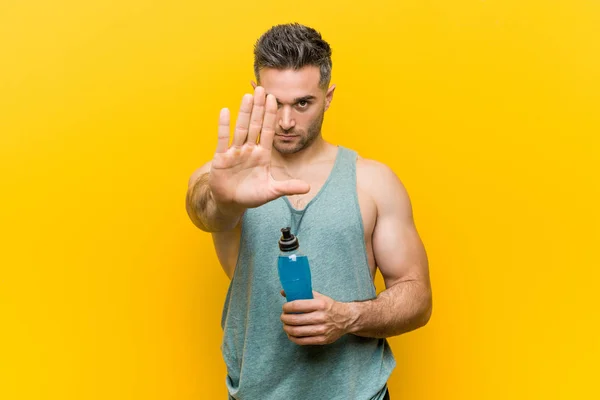Kaukasische Man Met Een Energiedrank Staande Met Uitgestrekte Hand Tonen — Stockfoto