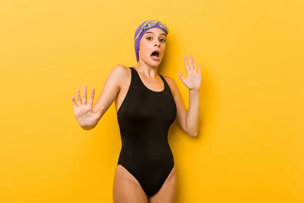Young swimmer caucasian woman being shocked due to an imminent danger