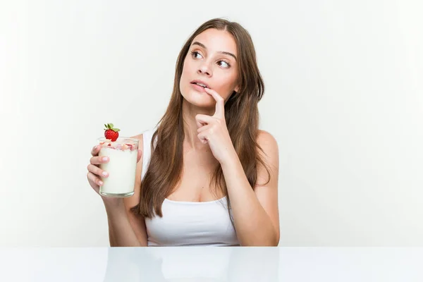 Young Caucasian Woman Holding Smoothie Relaxed Thinking Something Looking Copy — Stock Photo, Image