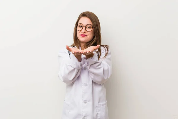 Jonge Dokter Vrouw Tegen Een Witte Muur Die Iets Met — Stockfoto