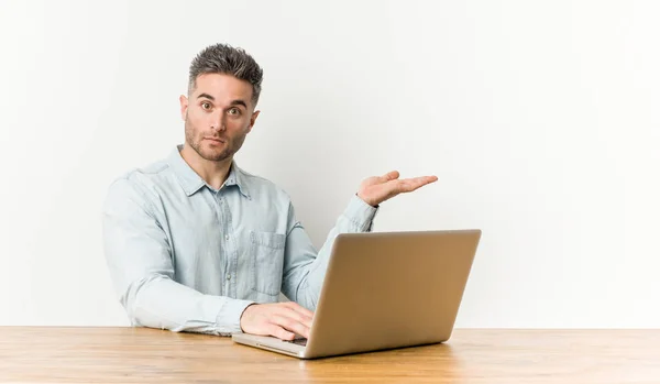 Jovem Homem Bonito Trabalhando Com Seu Laptop Mostrando Espaço Cópia — Fotografia de Stock