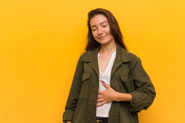 Jonge Europese Vrouw Geïsoleerd Gele Achtergrond Raakt Buik Glimlacht Zachtjes — Stockfoto