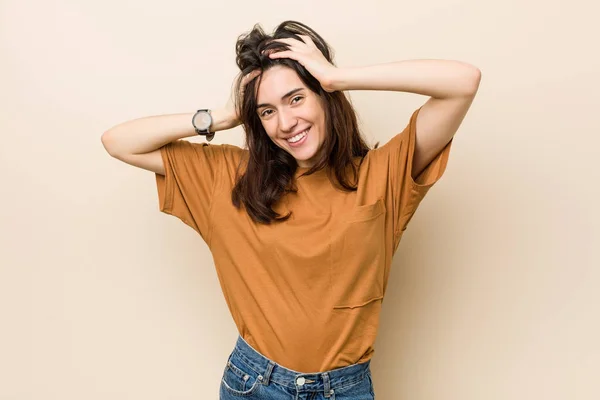 Jonge Brunette Vrouw Tegen Een Beige Achtergrond Lacht Vreugdevol Handen — Stockfoto