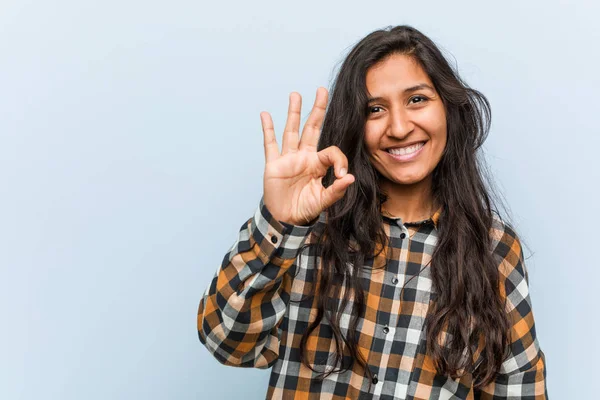 Young cool indian woman cheerful and confident showing ok gesture.