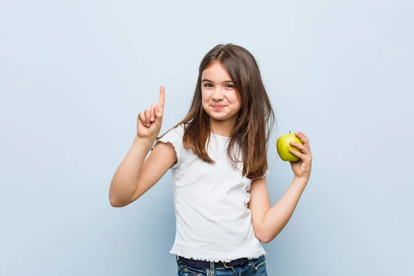 Little Caucasian Girl Holding Green Apple Showing Number One Finger — Stock Photo, Image