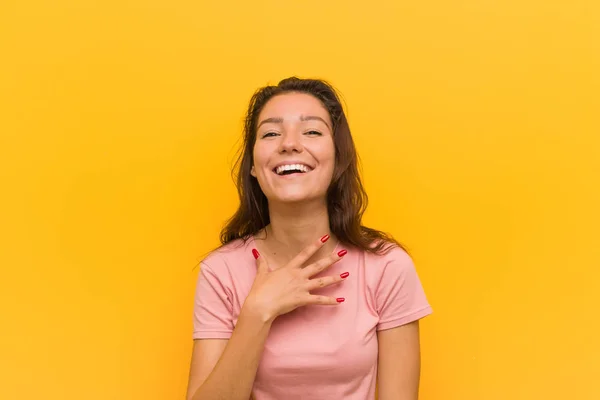 Jonge Europese Vrouw Geïsoleerd Gele Achtergrond Lacht Hardop Hand Borst — Stockfoto