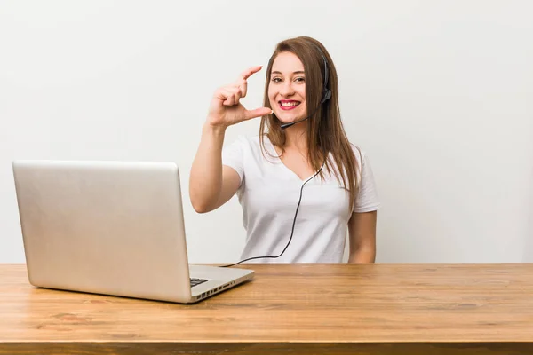 Mulher Jovem Telemarketer Segurando Algo Pouco Com Dedos Indicador Sorrindo — Fotografia de Stock