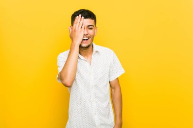 Genç İspanyol adam palmiye ile yüz yarısını kapsayan eğleniyor.