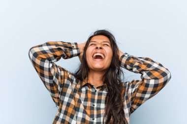 Genç serin hintli kadın sevinçle baş elleri tutarak gülüyor. Mutluluk kavramı.