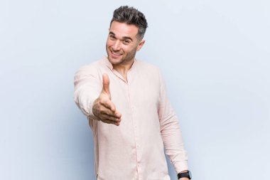 Genç yakışıklı serin adam tebrik jestkamera el germe.