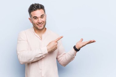 Genç yakışıklı serin adam avuç içi bir kopya alanı tutarak heyecanlı.