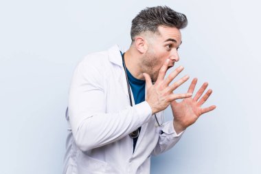 Genç yakışıklı doktor adam yüksek sesle bağırır, gözleri açık tutar ve eller gergin.