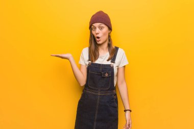 Genç hipster kadın avuç içi elinde bir şey tutan