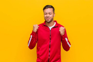 Genç filipinli fitness adam yumruk yükselterek, mutlu ve başarılı hissediyorum. Zafer kavramı.