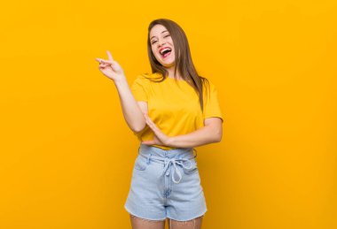 Genç kadın genç sarı gömlek neşeli ve kaygısız parmakları ile bir barış sembolü gösteren giyiyor.