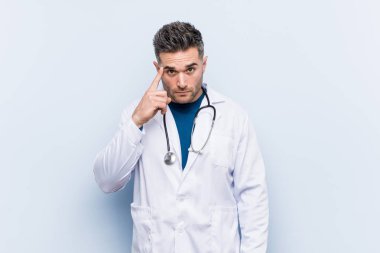 Genç yakışıklı doktor adam parmak ile tapınak işaret, düşünme, bir görev üzerinde duruldu.