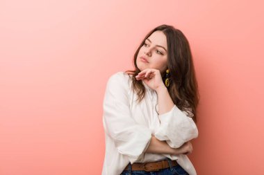 Pembe arka planda Genç beyaz Curvy kadın ayakta