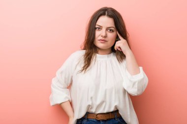 Pembe arka planda Genç beyaz Curvy kadın ayakta