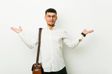 Genç İspanyol rahat iş adamı silah ile ölçek yapar, mutlu ve kendinden emin hissediyor.