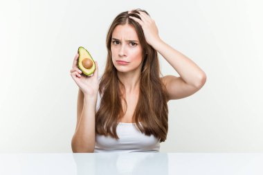 Avokado tutan genç beyaz kadın şok eyledi, önemli bir toplantıyı hatırladı.