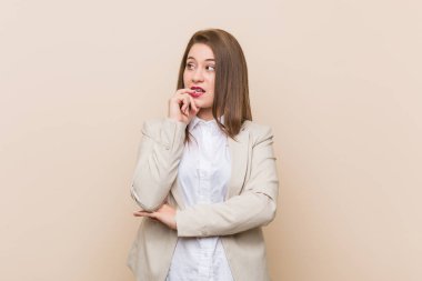 Genç iş kadını bir kopya alanı bakarak bir şey hakkında düşünme rahat.