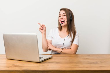 Genç telemarketer kadın neşeyle uzak işaret parmağı ile işaret gülümseyen.