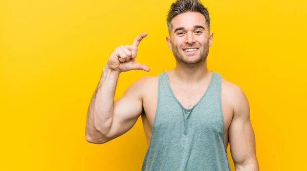 Mladý Fitness Muž Žlutém Pozadí Ukazováky Usmívajícími Sebevědomými — Stock fotografie