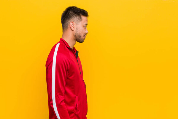 Young filipino fitness man gazing left, sideways pose.