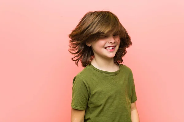 ピンクの背景に対して遊ぶ小さな白人の少年 — ストック写真