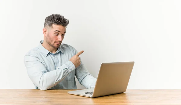 Jovem Homem Bonito Trabalhando Com Seu Laptop Sorrindo Apontando Para — Fotografia de Stock