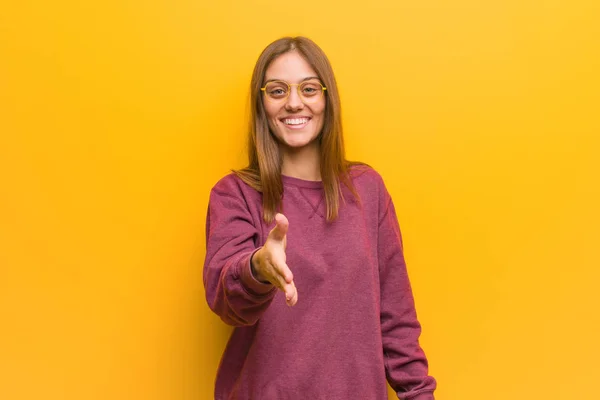 Young casual woman reaching out to greet someone