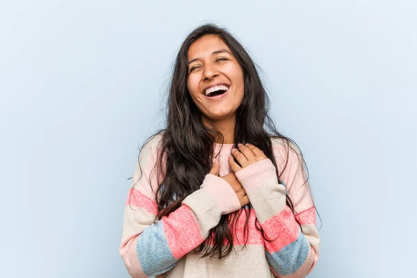 Young fashion indian woman laughing keeping hands on heart, concept of happiness.