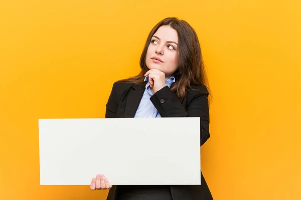 Young Size Curvy Woman Holding Placard Looking Sideways Doubtful Skeptical — Stock Photo, Image