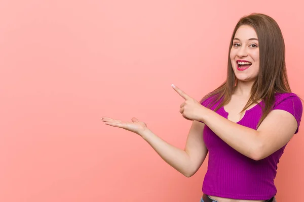 Young Hispanic Woman Pink Wall Excited Holding Copy Space Palm — Stock Photo, Image