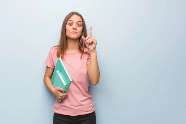 Joven Mujer Bastante Caucásica Mostrando Número Uno Ella Tiene Libros — Foto de Stock