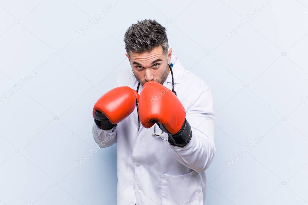 Caucasian doctor man wearing boxing gloves