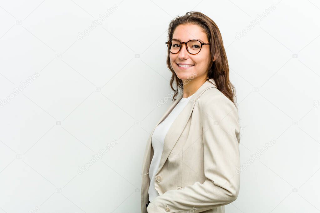 Young european business woman looks aside smiling, cheerful and pleasant.