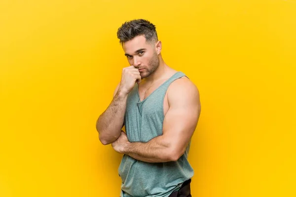Caucasian trainer man posing against a yellow background