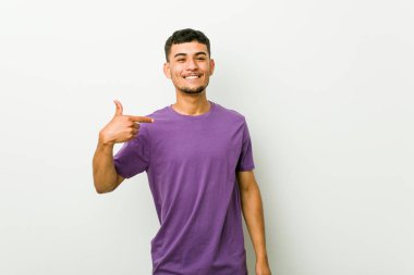 Genç İspanyol adam bir gömlek kopyalama alanı, gururlu ve kendinden emin elle işaret