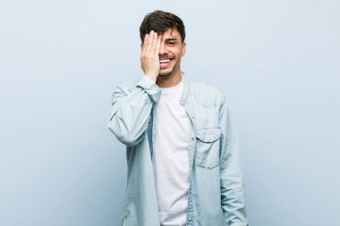 Genç İspanyol serin adam palmiye ile yüz yarısını kapsayan eğlenmek.