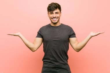 Genç İspanyol rahat adam kolları ile ölçek yapar, mutlu ve kendinden emin hissediyor.