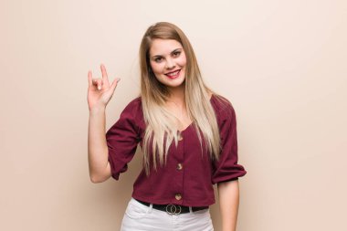 Young russian woman doing a rock gesture