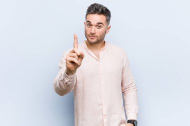 Genç yakışıklı serin adam parmak ile bir numara gösteren.