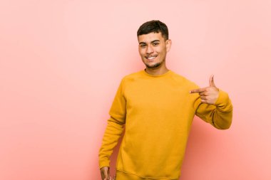 Genç İspanyol adam bir gömlek kopyalama alanı, gururlu ve kendinden emin elle işaret